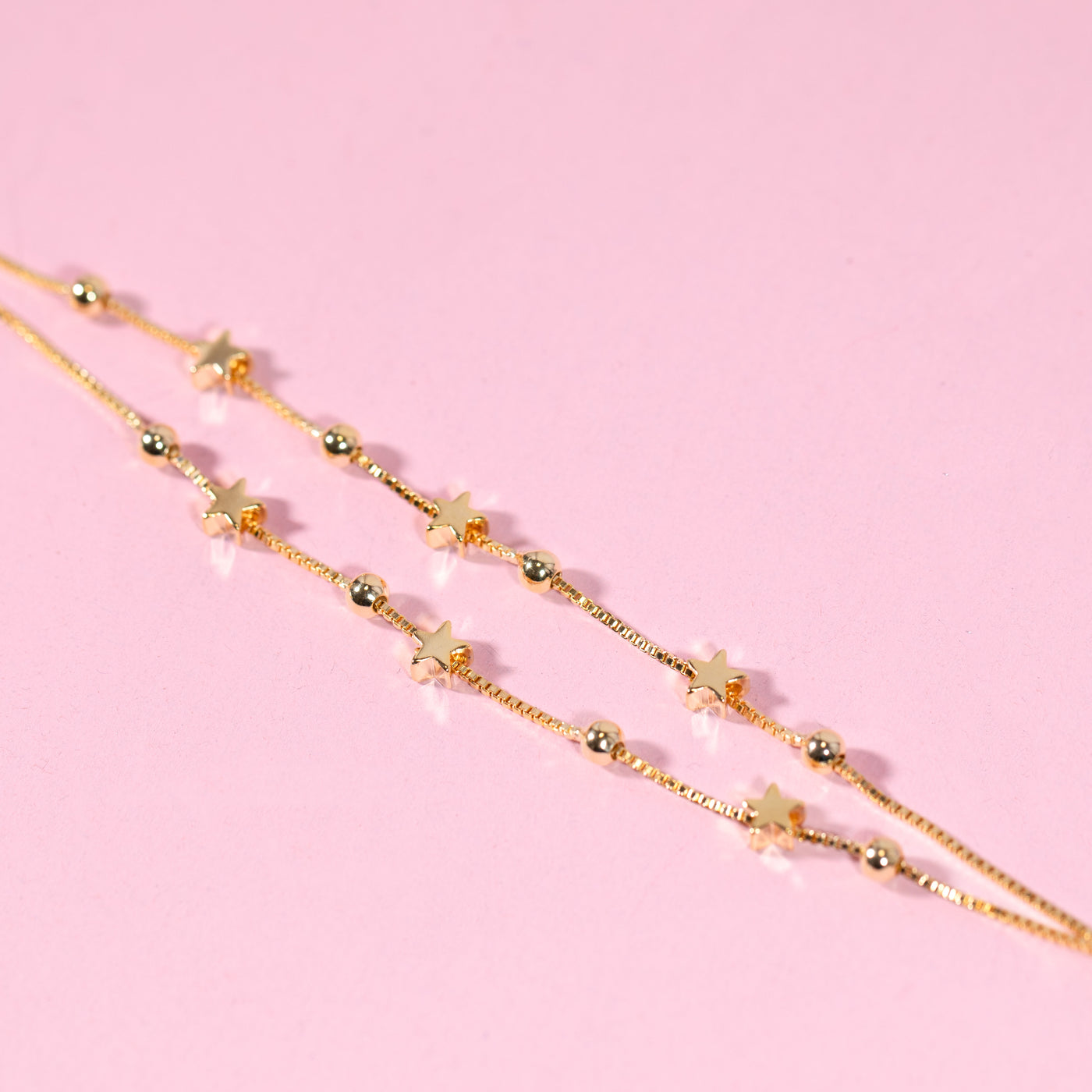 Gold-plated bracelet for a friend. A gift under £20 on a pink background