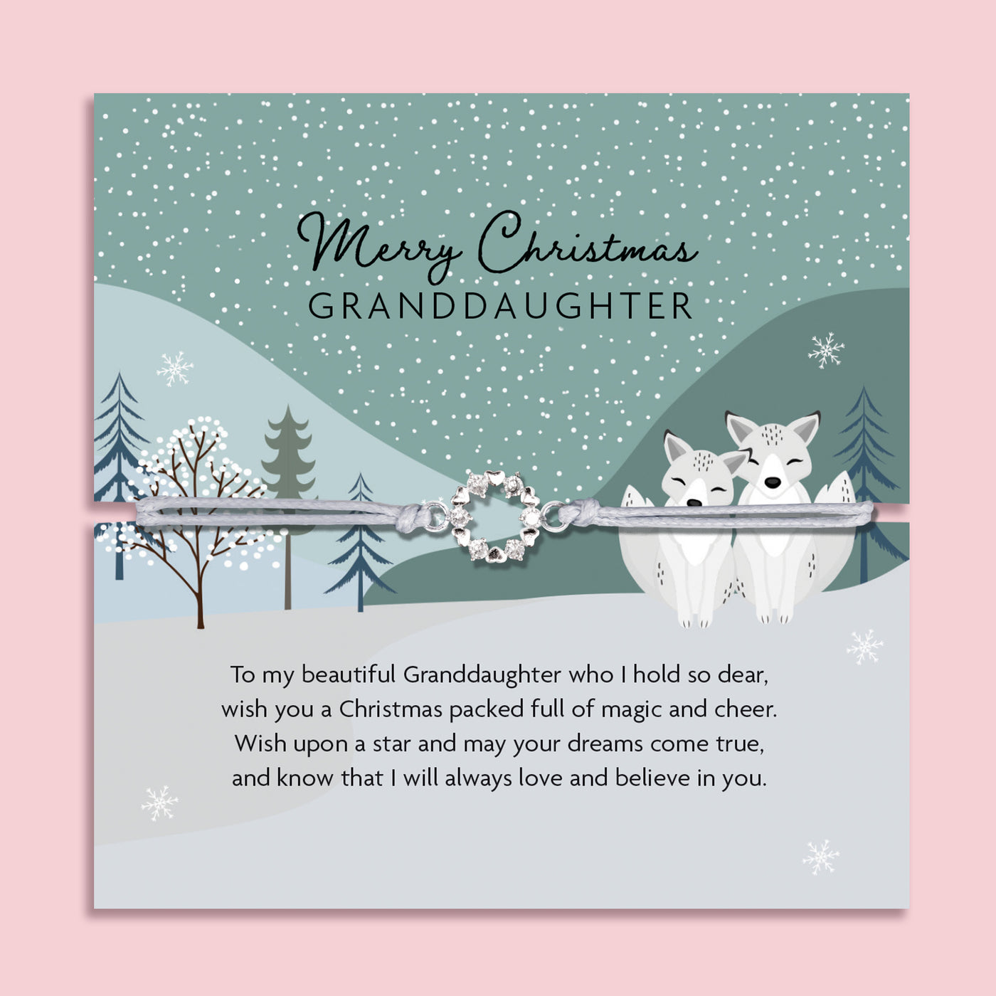 Merry Christmas Granddaughter bracelet featuring a silver wreath charm on an adjustable cord, presented on a festive green card with bells, mistletoe, Christmas trees, and snowy details. Includes a soft white pouch for gifting and safekeeping. A sentimental Christmas jewellery gift for granddaughters of all ages, perfect as a stocking filler, Christmas morning surprise, or heartfelt keepsake from grandparents. A meaningful holiday bracelet celebrating love and family.