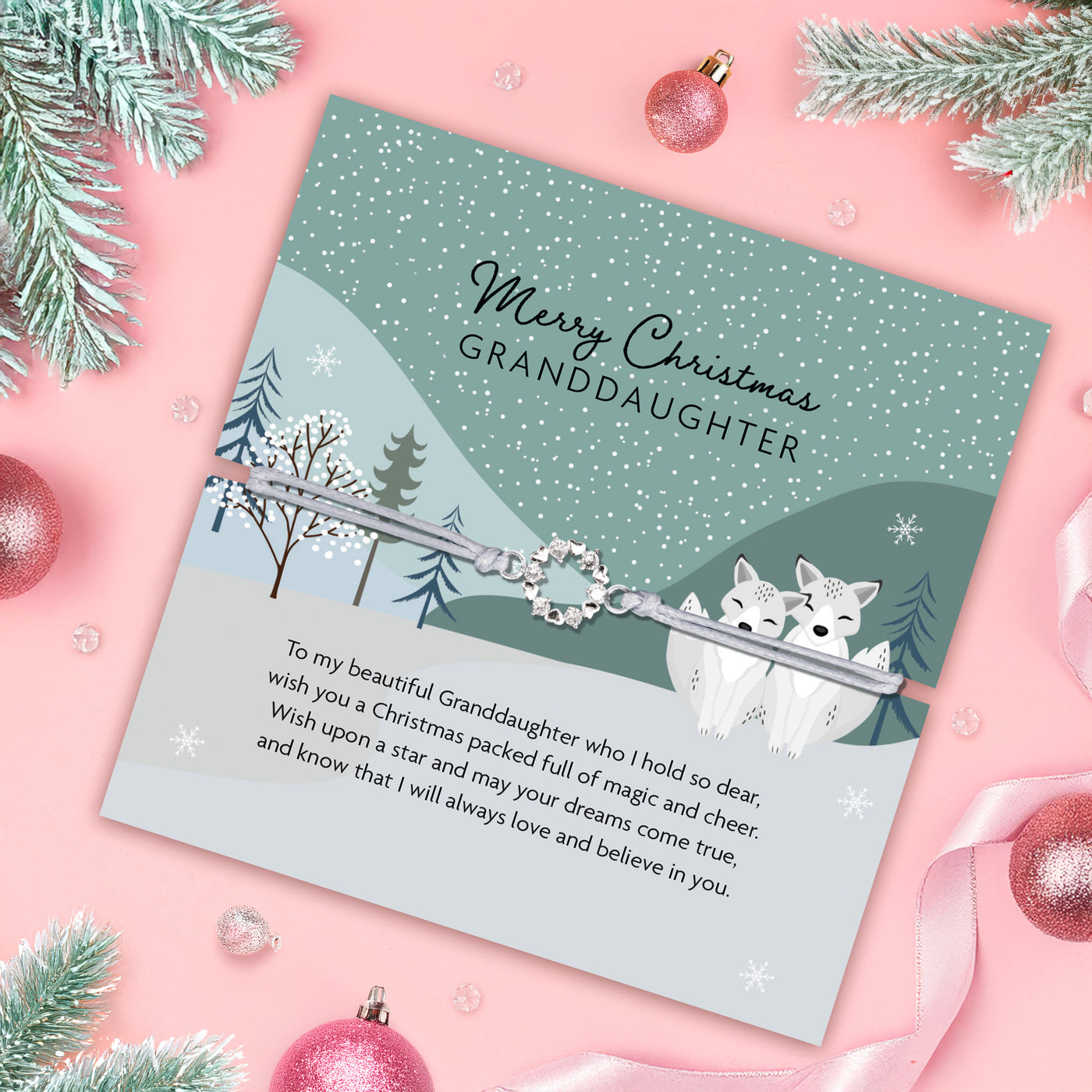 Christmas poem card with a silver wreath charm for a granddaughter, surrounded by festive decorations.