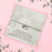 A silver beaded bracelet with a heart and flower charm displayed on a card reading "To my Lovely Grandma" from Letterbox Love, set against a soft pink background with eucalyptus leaves and small crystals. The card includes a heartfelt poem, making it a perfect sentimental gift for a grandma.