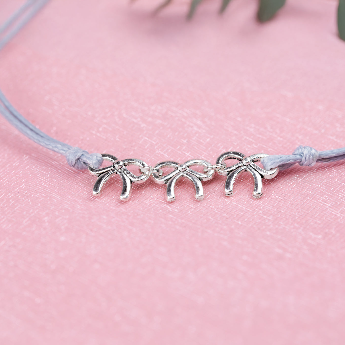 Grey cord friendship bracelet with three cute bow bracelets, creating a perfect gift for hen do favours under £10