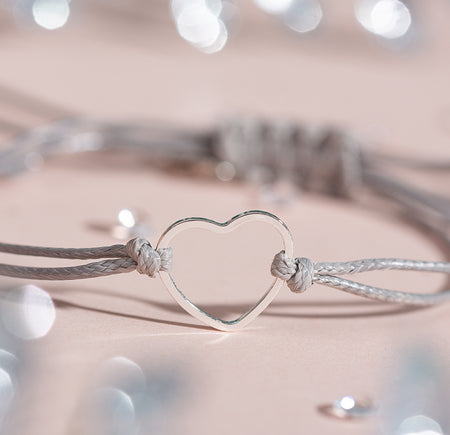 Bracelet with a heart-shaped clasp on a soft background. A wonderful gift for a stocking filler or secret Santa present