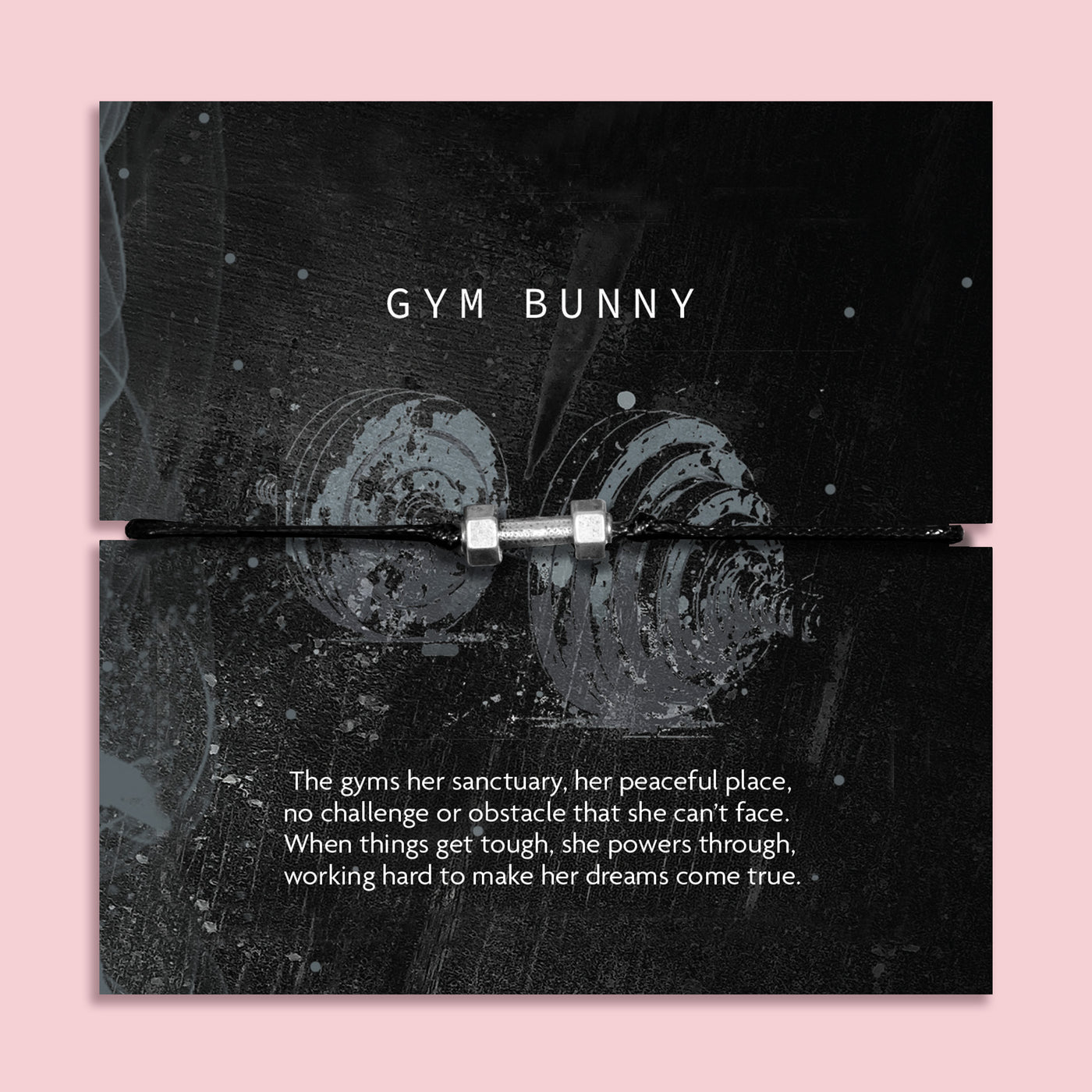 A black cord bracelet with a silver plated charm shaped like a dumbbell, presented on a black backing card with the text 'GYM BUNNY' and a motivational quote, set against a solid pink background.