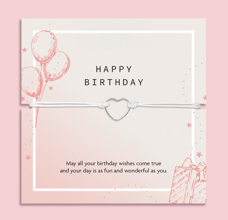 Letterbox Love happy birthday bracelet gift – dainty heart charm on a white cord, presented on a pastel pink birthday card with a sweet message, perfect affordable jewellery gift for her, friend or teen.