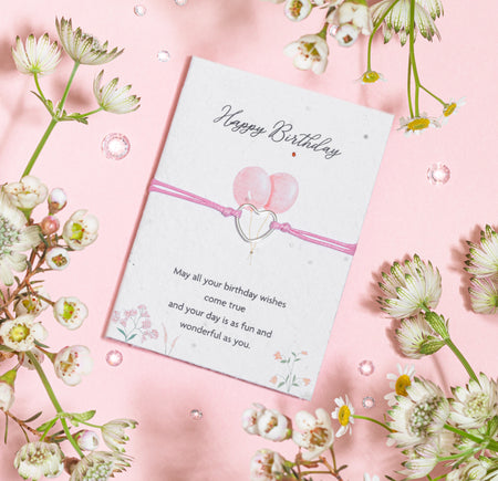 A birthday greeting card on a pink background with the message 
