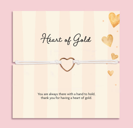 Heart of Gold adjustable white cord bracelet with gold-tone open heart charm displayed on a cream and gold sentiment card reading “Thank you for having a heart of gold.”