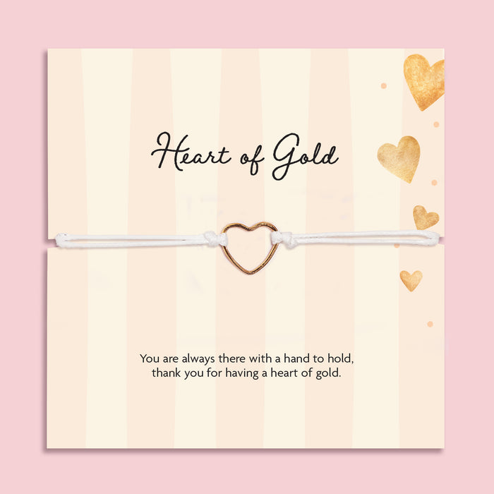 Heart of Gold adjustable white cord bracelet with gold-tone open heart charm displayed on a cream and gold sentiment card reading “Thank you for having a heart of gold.”