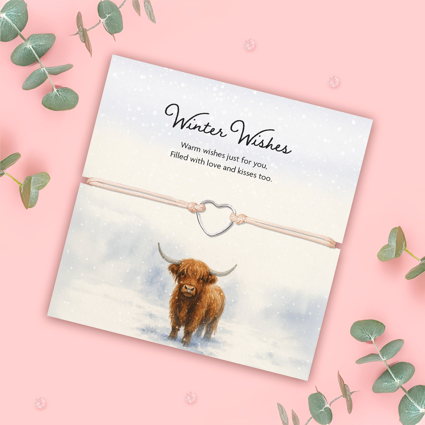 Card with a highland cow illustration and 'Winter Wishes' text on a pink background with eucalyptus leaves. Xmas gift for women.