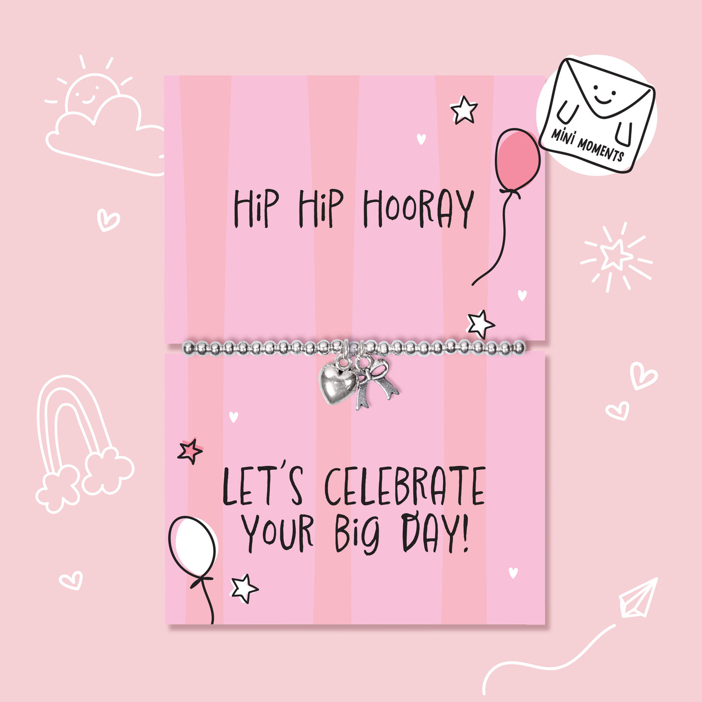 A silver beaded bracelet with a heart and key charm displayed on a pink striped gift card that reads 'Hip Hip Hooray' and 'LET'S CELEBRATE YOUR BIG DAY!'. The card is decorated with hand-drawn doodles of stars, hearts, a balloon, and a rainbow, set against a solid pink background with a 'Mini Moments' logo in the top right corner.