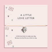 Bracelet with heart charm on a card labeled 'A Little Love Letter' against a pink background. A gift to say 'I love you'