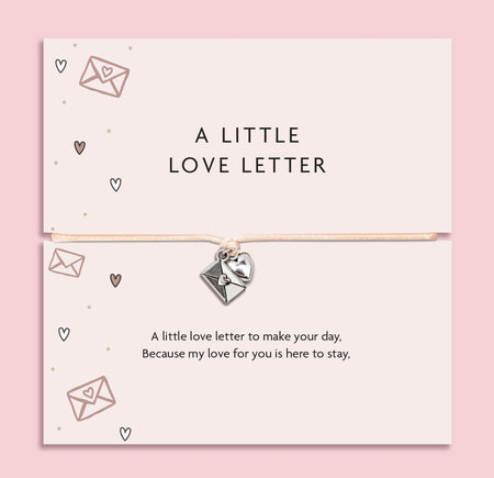 Bracelet with heart charm on a card labeled 'A Little Love Letter' against a pink background. A gift to say 'I love you'