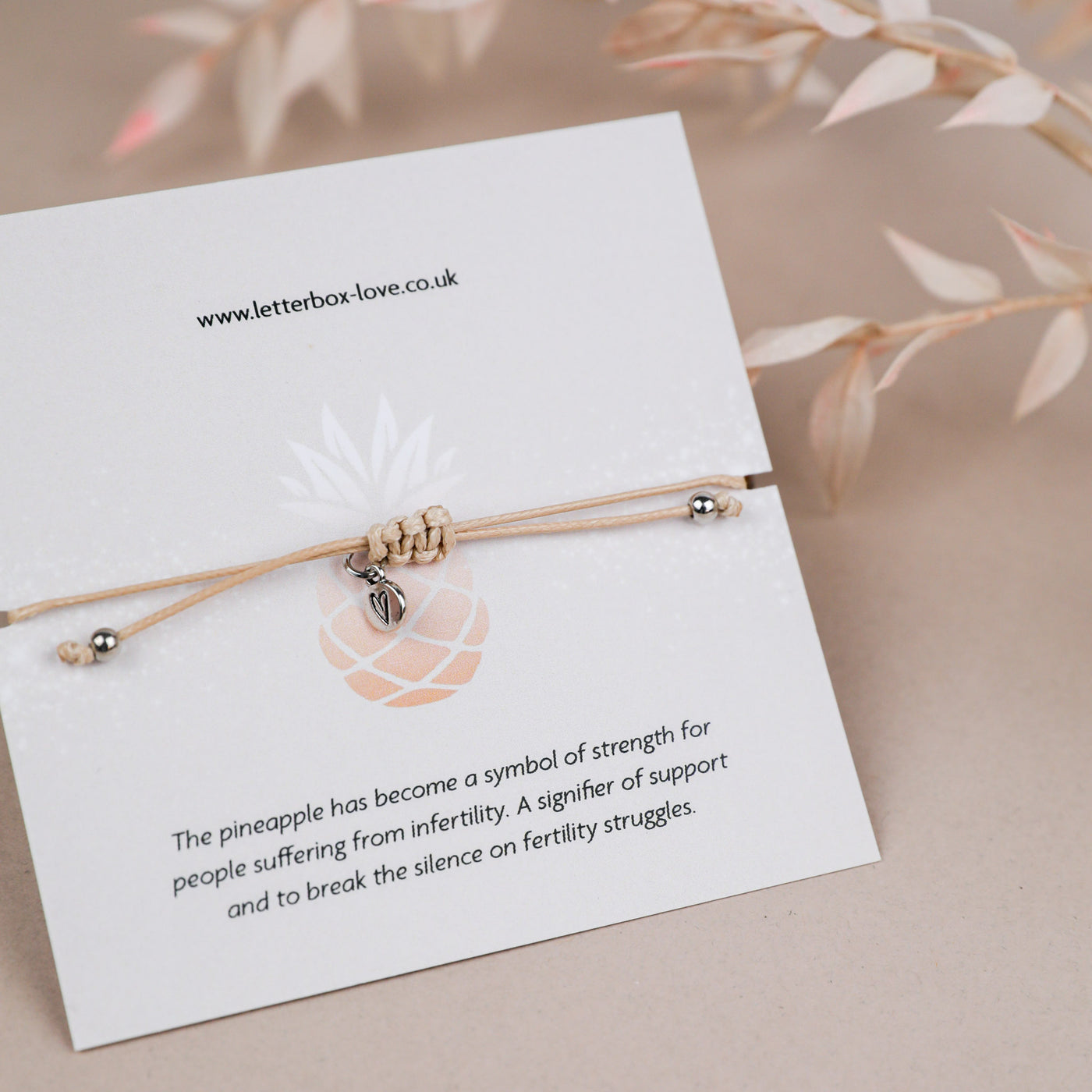 A poem card with the description of why a pineapple is used to symbolise IVF. On a beige background.