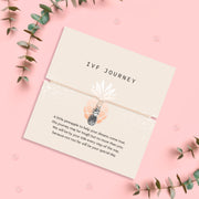 Pineapple charm bracelet for IVF journey, presented with a heartfelt sentiment card offering encouragement and support. The design includes a small silver pineapple charm on a beige cord with a meaningful message.