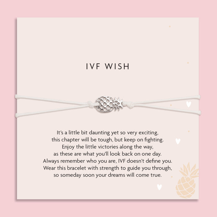 Bracelet with pineapple charm on a card with 'IVF Wish' text against a pink background. A gift for someone beginning IVF.