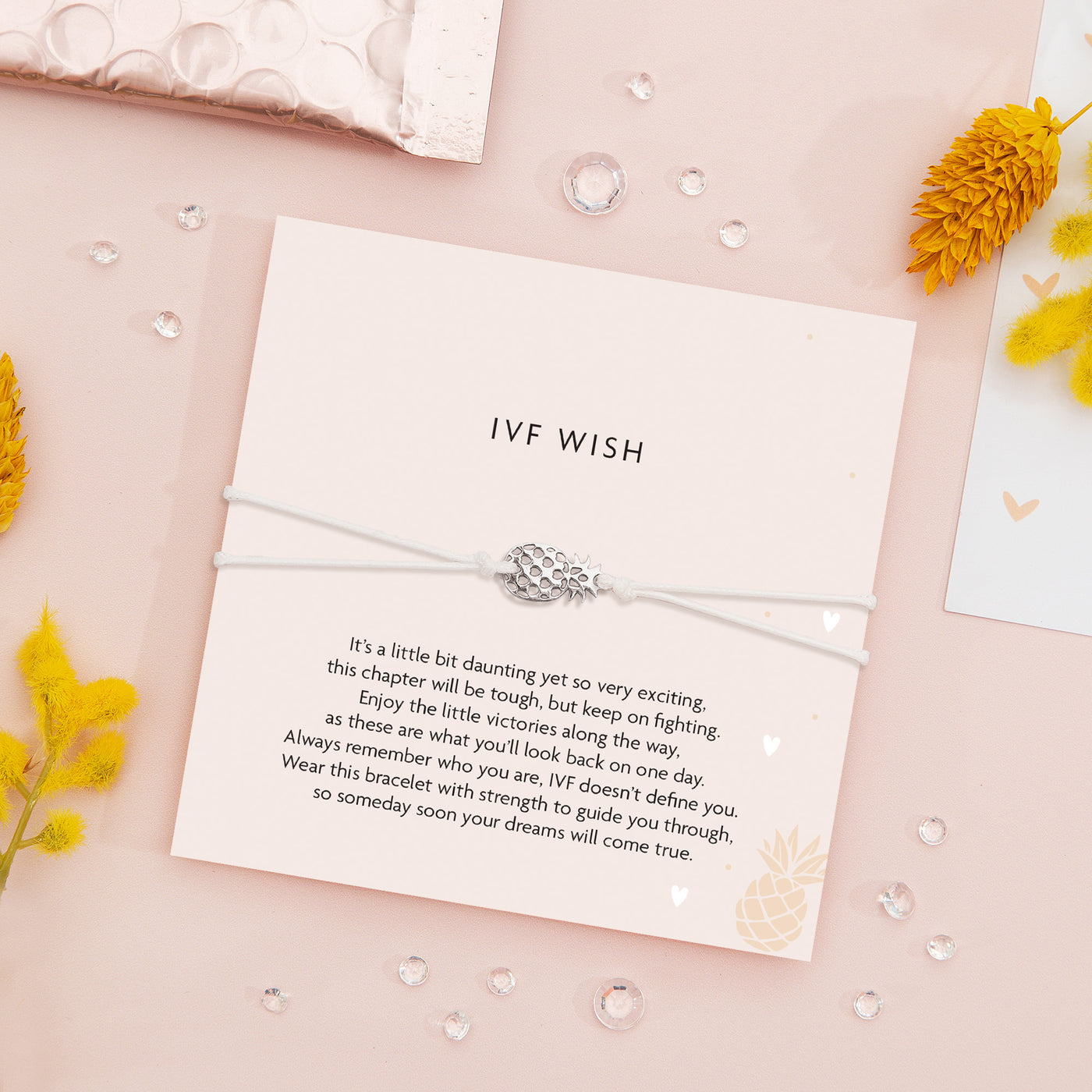 IVF Wish bracelet featuring a silver pineapple charm on a white adjustable cord, with a thoughtful IVF encouragement message.
