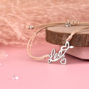 Silver necklace with 'love' pendant on a pink background. Affordable star sign jewellery for women. Leo bracelet under £20