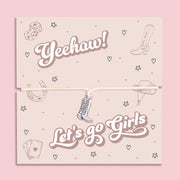 Let’s Go Girls cowgirl bracelet featuring a silver-tone cowboy boot charm on an adjustable cord. Presented on a playful Yeehaw themed card with Western icons, this bracelet is the perfect Nashville bachelorette gift, country music festival accessory, or fun keepsake for bridesmaids and best friends. A trendy Western jewellery piece ideal for hen parties, rodeo nights, stocking fillers, or as a unique gift for her who loves the cowgirl aesthetic.