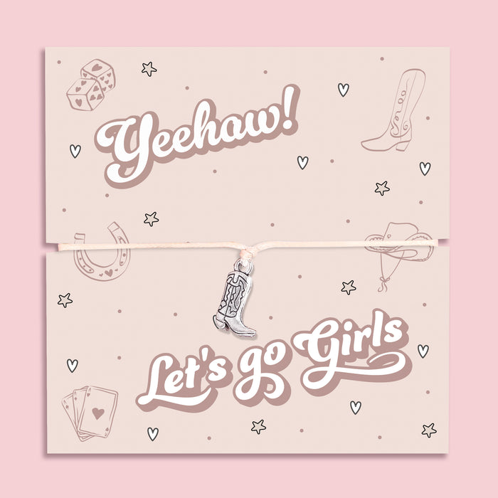 Let’s Go Girls cowgirl bracelet featuring a silver-tone cowboy boot charm on an adjustable cord. Presented on a playful Yeehaw themed card with Western icons, this bracelet is the perfect Nashville bachelorette gift, country music festival accessory, or fun keepsake for bridesmaids and best friends. A trendy Western jewellery piece ideal for hen parties, rodeo nights, stocking fillers, or as a unique gift for her who loves the cowgirl aesthetic.