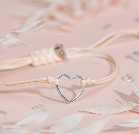 Heart-shaped bracelet with gems on a soft pink background, a cute beige bracelet gift