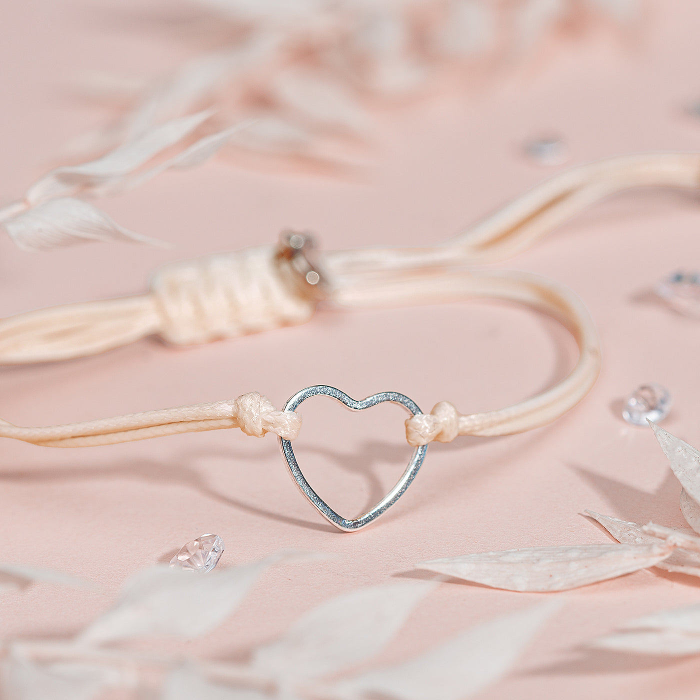 Heart-shaped bracelet with gems on a soft pink background, a cute beige bracelet gift