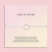 A pale pink background with a 'like a sister' poem card and meaningful message, with a friendship bracelet white string and hollow silver heart