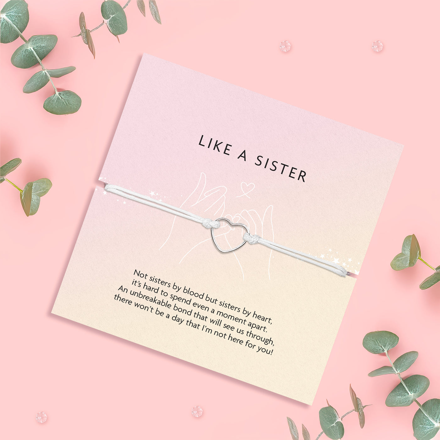 A silver string friendship bracelet with a 'like a sister' meaningful poem card surrounded by eucalyptus leaves
