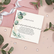 A 'LIMITLESS' encouragement card by Letterbox Love, set on a pastel pink background. The card features elegant botanical illustrations with silver eucalyptus leaves and gold accents. Encouraging gift for a friend.