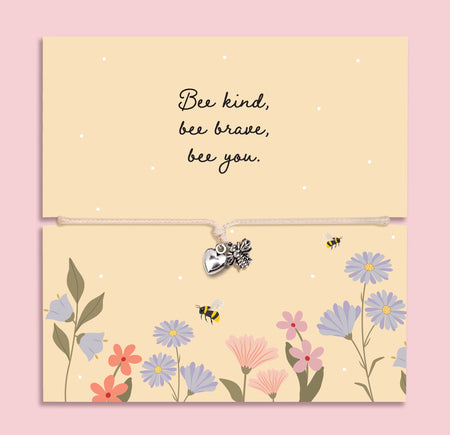 Adjustable cord bracelet with silver bee charm and heart charm displayed on a floral “Bee Kind Bee Brave Bee You” message card, inspirational encouragement gift bracelet for friend or daughter.