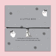 Silver ghost charm bracelet on black cord, displayed on grey Halloween-themed card with spiderweb and heart illustrations.