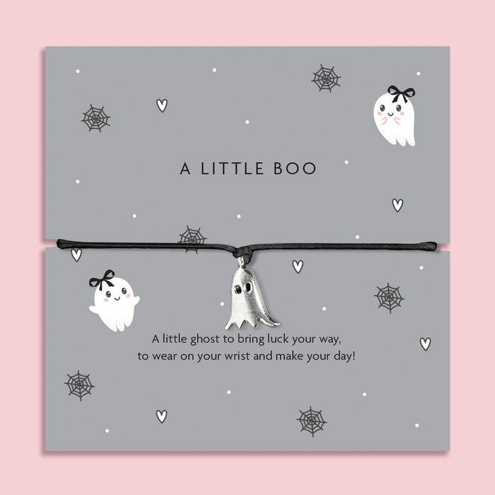 Silver ghost charm bracelet on black cord, displayed on grey Halloween-themed card with spiderweb and heart illustrations.