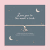 Love You to the Moon and Back bracelet with silver moon and star charms on an adjustable cord, displayed on a blue illustrated keepsake card with sentimental message