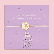 A delicate bracelet with an enamel daisy charm on an adjustable white cord, displayed on a lilac backing card with the message "Mum, You're Bloomin' Brilliant!" 