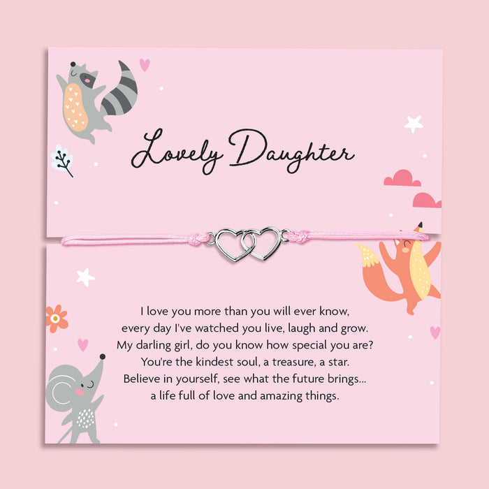Pink adjustable string bracelet with two silver interlocking heart charms, displayed on a card that reads "Lovely Daughter" with an illustrated fox, raccoon, and poem.