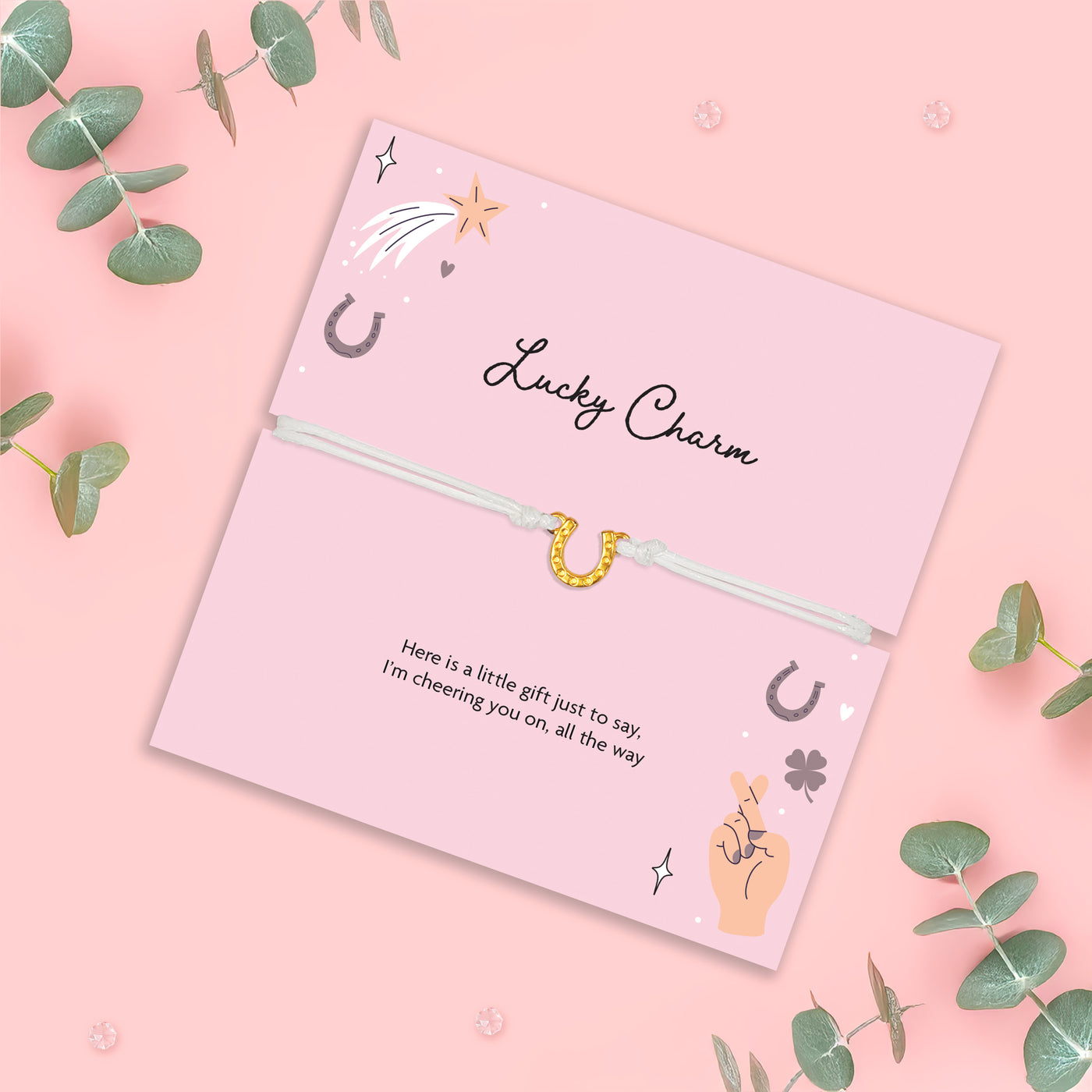Pink card with 'Lucky Charm' text and illustrations on a pink background with green leaves.