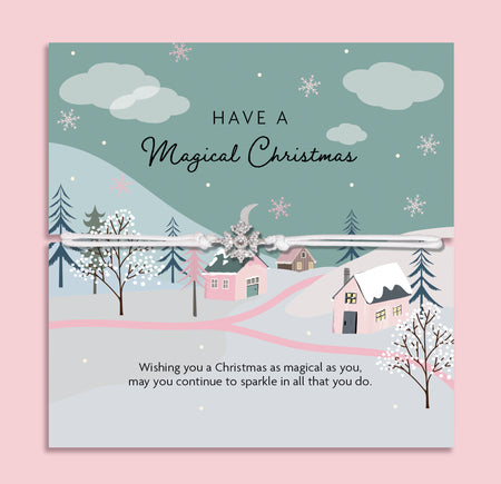 Magical Christmas snowflake bracelet featuring a silver snowflake charm on an adjustable cord, presented on a festive card with pastel winter village scene, snowy trees, and falling snowflakes. Includes a soft white pouch for gifting and safekeeping. Perfect Christmas jewellery gift for her, ideal as a stocking filler, Secret Santa present, or festive keepsake. A thoughtful holiday bracelet symbolising the sparkle and magic of Christmas and winter.