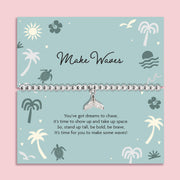 Bracelet with a whale tail charm on a decorative card with ocean-themed illustrations. Holiday silver-plated bracelet.