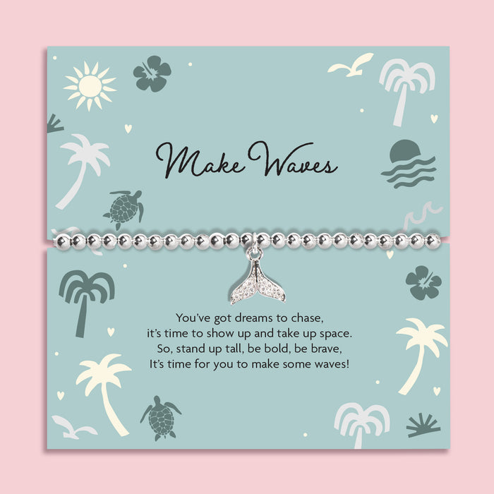 Bracelet with a whale tail charm on a decorative card with ocean-themed illustrations. Holiday silver-plated bracelet.