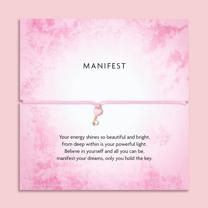Pink 'Manifest' bracelet with heart key charm on a soft pink poem card with a motivational message. A motivational gift for a friend. 