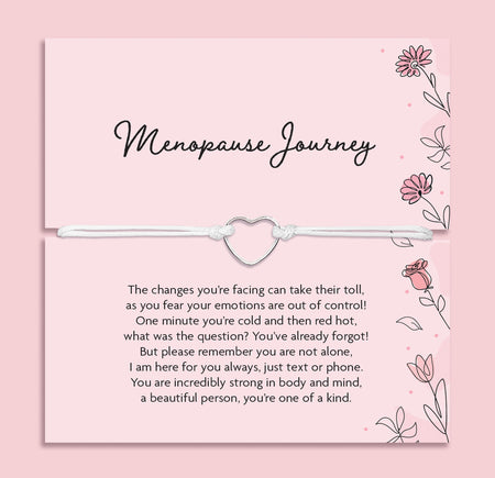 Pink menopause journey gift card featuring a white cord bracelet with a silver heart charm, presented across the card with supportive menopause poem text and delicate floral illustrations, designed as a thoughtful menopause support gift.