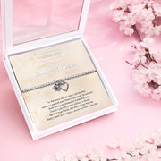 A silver beaded bracelet with a heart and flower charm displayed on a card reading "To my Wonderful Mother" from Letterbox Love, set against a soft pink background with white flowers and small crystals. The card features a heartfelt poem, making it a perfect sentimental gift for a mother