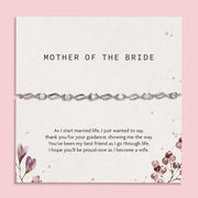 Bracelet on a card with 'Mother of the Bride' text and floral design on a pink background. An elegant silver bracelet for the Mother of the Bride. Wedding gifts.