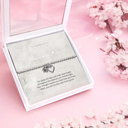 Silver beaded bracelet with heart and flower charms, displayed in a white gift box alongside a card titled "To My Wonderful Mum." The card features a heartfelt message celebrating a mother’s strength, love, and inspirational presence.