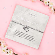 A silver beaded bracelet with a heart and flower charm displayed on a card reading "To my Wonderful Mum" from Letterbox Love, set against a soft pink background with white flowers and small crystals. The card features a heartfelt poem, making it a perfect sentimental gift for a Mum
