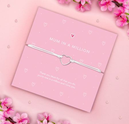 Mum in a Million bracelet with a silver heart charm on a white cord, presented on a pink card with the message 'Thank you Mum for all that you do, you're one in a million and I love you.