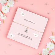 A soft pink bracelet card with a cute teddy bear charm, featuring the text "MUMMY BEAR" and a heartfelt message, "A little thank you for all that you do, you're my mummy bear and I love you!" surrounded by adorable bear illustrations.