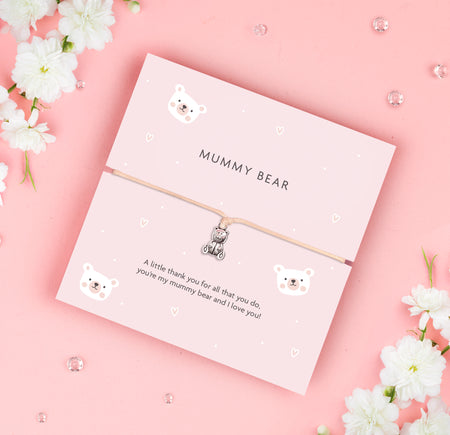 A soft pink bracelet card with a cute teddy bear charm, featuring the text 