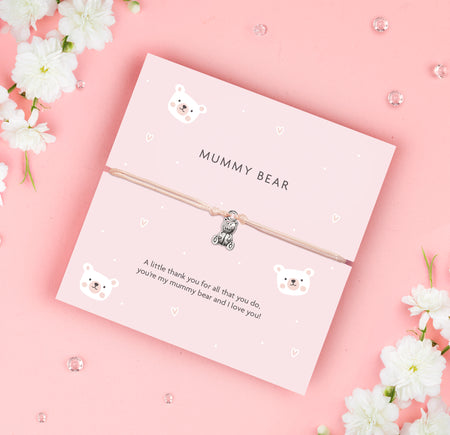 A soft pink bracelet card with a cute teddy bear charm, featuring the text 