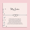 My Sister bracelet featuring two silver interlocking heart charms on an adjustable cord, presented on a blush pink card with a heartfelt message about sisterhood. Wrapped in pink tissue paper, ready for gifting. A sentimental jewellery gift for sisters, perfect for birthdays, Christmas, or just to show appreciation. A meaningful bracelet symbolising love, friendship, and connection between sisters.