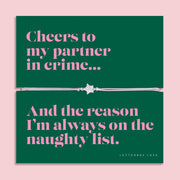 Partner in Crime Christmas bracelet featuring a sparkling cubic zirconia star charm on an adjustable cord, presented on a bold green card with the fun message “Cheers to my partner in crime… and the reason I’m always on the naughty list.” Arrives beautifully gift wrapped. A playful and thoughtful Christmas jewellery gift for friends, perfect as a stocking filler, Secret Santa surprise, or festive keepsake for your bestie.