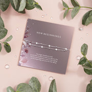 Silver bracelet with star and bead charms, perfect for celebrating new beginnings. Presented on a 'New Beginnings' card featuring an inspiring message about success, fresh starts, and achieving dreams. Ideal gift for someone starting a new chapter, whether it’s a career, graduation, or personal milestone.